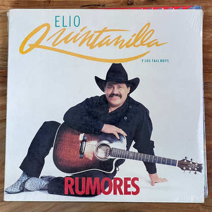 Vinyl record cover featuring a person with a guitar on a wooden surface