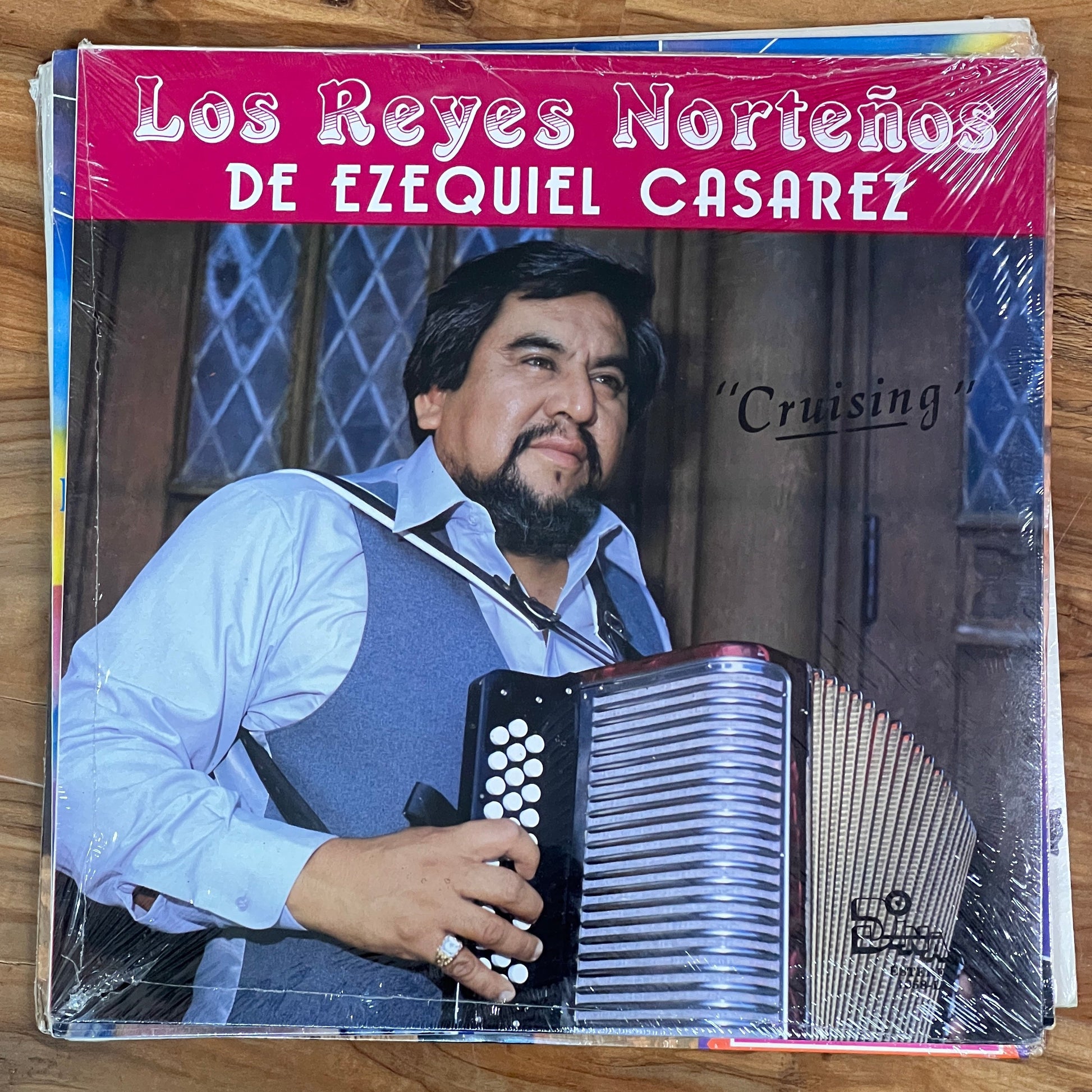 Vinyl record cover featuring a man with an accordion on a wooden surface